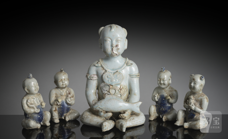 A large 'qingbai' style porcelain sculpture of a boy holding a fish and four small boys